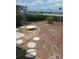 Back yard with mulch, stepping stones, a small bench, and perimeter bushes at 8008 La Serena Dr, Tampa, FL 33614