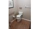 Bathroom features a toilet with safety bars, wood-look flooring, and framed artwork at 8008 La Serena Dr, Tampa, FL 33614