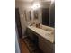 Bathroom with double sink vanity, large mirrors, and wood-look flooring at 8008 La Serena Dr, Tampa, FL 33614