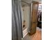 Bathroom showcasing a tub and shower with wood-look flooring, along with a curtain and a door at 8008 La Serena Dr, Tampa, FL 33614