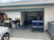 View of a messy open garage, full of storage items, with shelving at 8008 La Serena Dr, Tampa, FL 33614