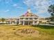 Elegant clubhouse featuring manicured landscaping, a clock tower and the American flag at 8137 Morning View Dr, Hudson, FL 34667