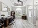 Open foyer with high ceilings and wood-style floors with arched window and double doors at 8137 Morning View Dr, Hudson, FL 34667