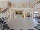 Hall with second floor overlooking stage, white columns, ceiling fans and a chandelier at 8137 Morning View Dr, Hudson, FL 34667