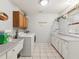 Functional laundry room with tile floor, ample storage, washer, dryer and utility sink at 8137 Morning View Dr, Hudson, FL 34667