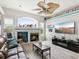 Inviting living room features a fireplace, ceiling fan, comfortable seating, and large windows at 8137 Morning View Dr, Hudson, FL 34667