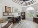 Home office with tray ceilings, wood-style floors, and a bright window at 8137 Morning View Dr, Hudson, FL 34667