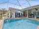 Inviting screened-in pool area offers sunny lounge areas and seating with water feature at 8137 Morning View Dr, Hudson, FL 34667