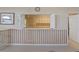 Serving area looking into the kitchen with white shutters and striped wallpaper at 8137 Morning View Dr, Hudson, FL 34667