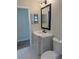 View of a bathroom featuring a modern vanity with a black framed mirror, sleek fixtures, and white porcelain toilet at 8413 Monarch Dr, Port Richey, FL 34668