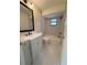 Bathroom with a modern vanity, framed mirror, tiled walls, and a bathtub with showerhead and dark hardware at 8413 Monarch Dr, Port Richey, FL 34668