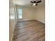 Bedroom featuring wood-look flooring, neutral walls, a ceiling fan, and a window at 8413 Monarch Dr, Port Richey, FL 34668