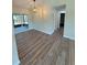 Open dining area with wood floors, modern lighting, and sliding glass doors leading to screened patio at 8413 Monarch Dr, Port Richey, FL 34668