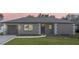 Charming single-story home featuring a well-manicured lawn, gray stucco, and an attached garage at 8413 Monarch Dr, Port Richey, FL 34668