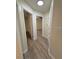 Hallway featuring wood-look floors leading to different rooms in the home at 8413 Monarch Dr, Port Richey, FL 34668