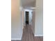 Hallway with neutral paint, wood-look flooring, white trim, and access to multiple rooms at 8413 Monarch Dr, Port Richey, FL 34668