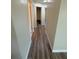 Hallway view with wood-look flooring and neutral paint, leading to various rooms at 8413 Monarch Dr, Port Richey, FL 34668