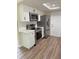 Stylish kitchen with stainless steel appliances, white cabinetry, quartz countertops, and new wood-look floors at 8413 Monarch Dr, Port Richey, FL 34668