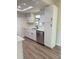 Modern kitchen with white cabinets, quartz countertops, stainless steel appliances, and new wood-look flooring at 8413 Monarch Dr, Port Richey, FL 34668
