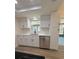 Modern kitchen features white cabinets, undermount sink, quartz countertops, stainless appliances and new floor at 8413 Monarch Dr, Port Richey, FL 34668