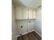 Small laundry room with overhead cabinets and vinyl flooring at 8413 Monarch Dr, Port Richey, FL 34668