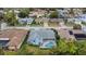 An aerial view capturing a screened-in pool and the lush greenery surrounding the neighborhood at 8514 Ashbury Dr, Hudson, FL 34667