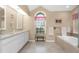 Elegant bathroom featuring double sinks, a soaking tub, and refined tile accents for a spa-like experience at 8514 Ashbury Dr, Hudson, FL 34667