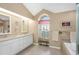 Elegant bathroom featuring double sinks, a soaking tub, and refined tile accents for a spa-like experience at 8514 Ashbury Dr, Hudson, FL 34667