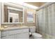 Bright bathroom featuring a single vanity, a window, and a shower with patterned curtain at 8514 Ashbury Dr, Hudson, FL 34667