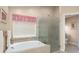 Well-lit bathroom offering a soaking tub, glass enclosed shower, and neutral decor at 8514 Ashbury Dr, Hudson, FL 34667