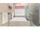 Serene bathroom featuring a garden tub with a glass enclosed shower, tiled backsplash, and neutral décor at 8514 Ashbury Dr, Hudson, FL 34667