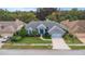 Aerial view of a home, showcasing its well-kept lawn, mature trees, and blue exterior at 8514 Ashbury Dr, Hudson, FL 34667