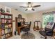 Functional home office setup with desk, bookshelves, guitars, and natural light at 8514 Ashbury Dr, Hudson, FL 34667