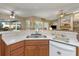 Open concept kitchen features stone countertops, stainless steel faucet, and wood cabinets at 8514 Ashbury Dr, Hudson, FL 34667