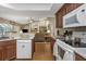 Open kitchen with white appliances, wood cabinets, and seamless flow to living spaces at 8514 Ashbury Dr, Hudson, FL 34667