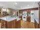 Well-lit kitchen featuring a breakfast bar, wood cabinets, and white appliances at 8514 Ashbury Dr, Hudson, FL 34667