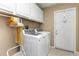 Bright laundry area with white appliances, cabinets and a door to the backyard at 8514 Ashbury Dr, Hudson, FL 34667