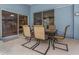 A comfortable patio is shown featuring a table with chairs, two sliding glass doors, and a blue wall at 8514 Ashbury Dr, Hudson, FL 34667