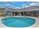 This screened-in pool is ready for relaxing and entertaining with an attached seating area at 8514 Ashbury Dr, Hudson, FL 34667