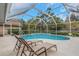 This pristine screened-in pool with poolside loungers offers the perfect place to relax at 8514 Ashbury Dr, Hudson, FL 34667