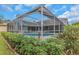 This is an outdoor pool surrounded by lush landscaping and a screened-in enclosure at 8514 Ashbury Dr, Hudson, FL 34667