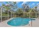 This is an inviting screened-in pool featuring clear blue water, and a safety railing at 8514 Ashbury Dr, Hudson, FL 34667