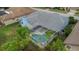 Aerial view of the property showcasing a lovely screened-in pool area surrounded by lush trees at 8514 Ashbury Dr, Hudson, FL 34667