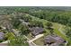 Aerial view of homes backing onto a golf course surrounded by a canopy of trees at 888 Royal Birkdale Dr, Tarpon Springs, FL 34688