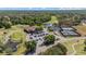 Aerial view of community featuring clubhouse, pond with fountain, tennis courts, and parking at 888 Royal Birkdale Dr, Tarpon Springs, FL 34688