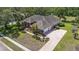 Aerial view of a spacious home with lush landscaping, a three car garage and a welcoming brick driveway at 888 Royal Birkdale Dr, Tarpon Springs, FL 34688