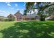 Expansive backyard view showcasing the manicured lawn and screened-in pool area, perfect for outdoor activities at 888 Royal Birkdale Dr, Tarpon Springs, FL 34688