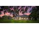 Backyard showcasing a screened lanai, green lawn, and a beautiful sunset, creating an inviting outdoor space at 888 Royal Birkdale Dr, Tarpon Springs, FL 34688