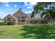 Well-maintained backyard with a manicured lawn and screened-in pool, perfect for outdoor living and entertaining at 888 Royal Birkdale Dr, Tarpon Springs, FL 34688