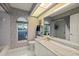 Well-lit bathroom featuring marble countertop, white cabinets, and a large mirror at 888 Royal Birkdale Dr, Tarpon Springs, FL 34688